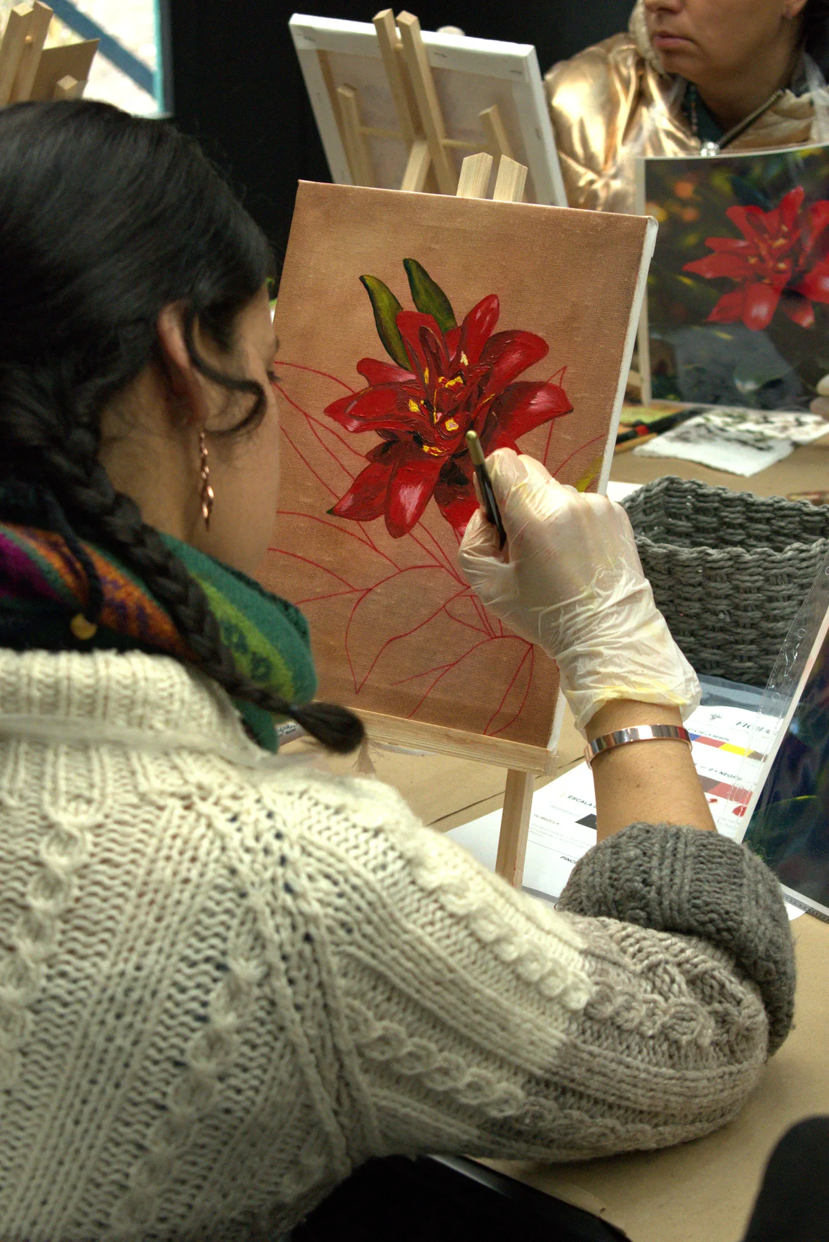 Participante terminando su bromelia al óleo sobre el caballete.
